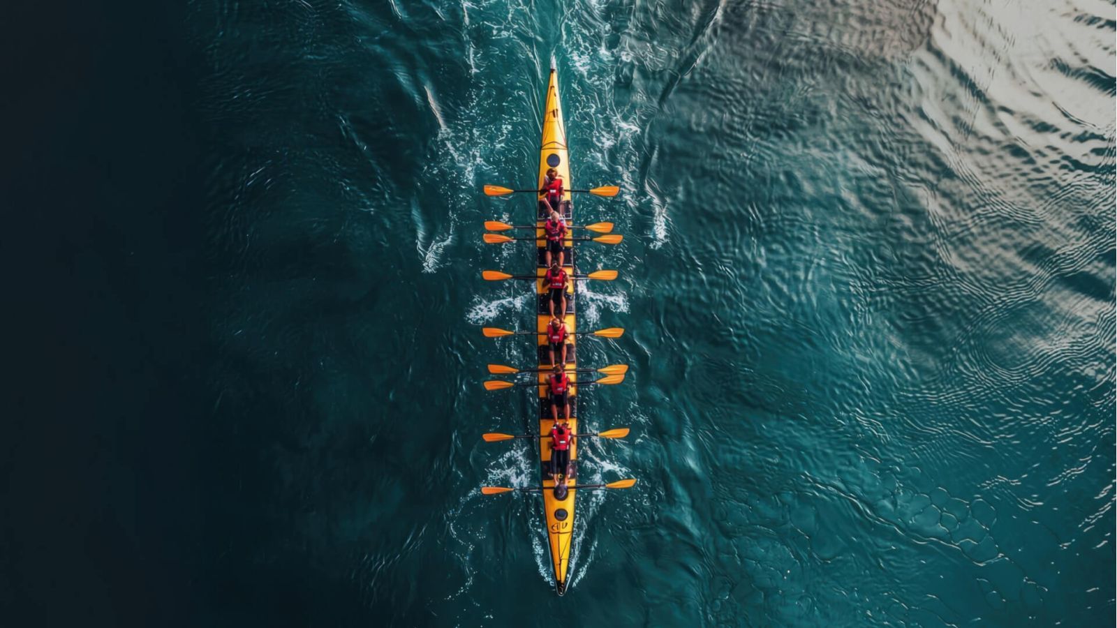 Rowing team racing in narrow boat on water