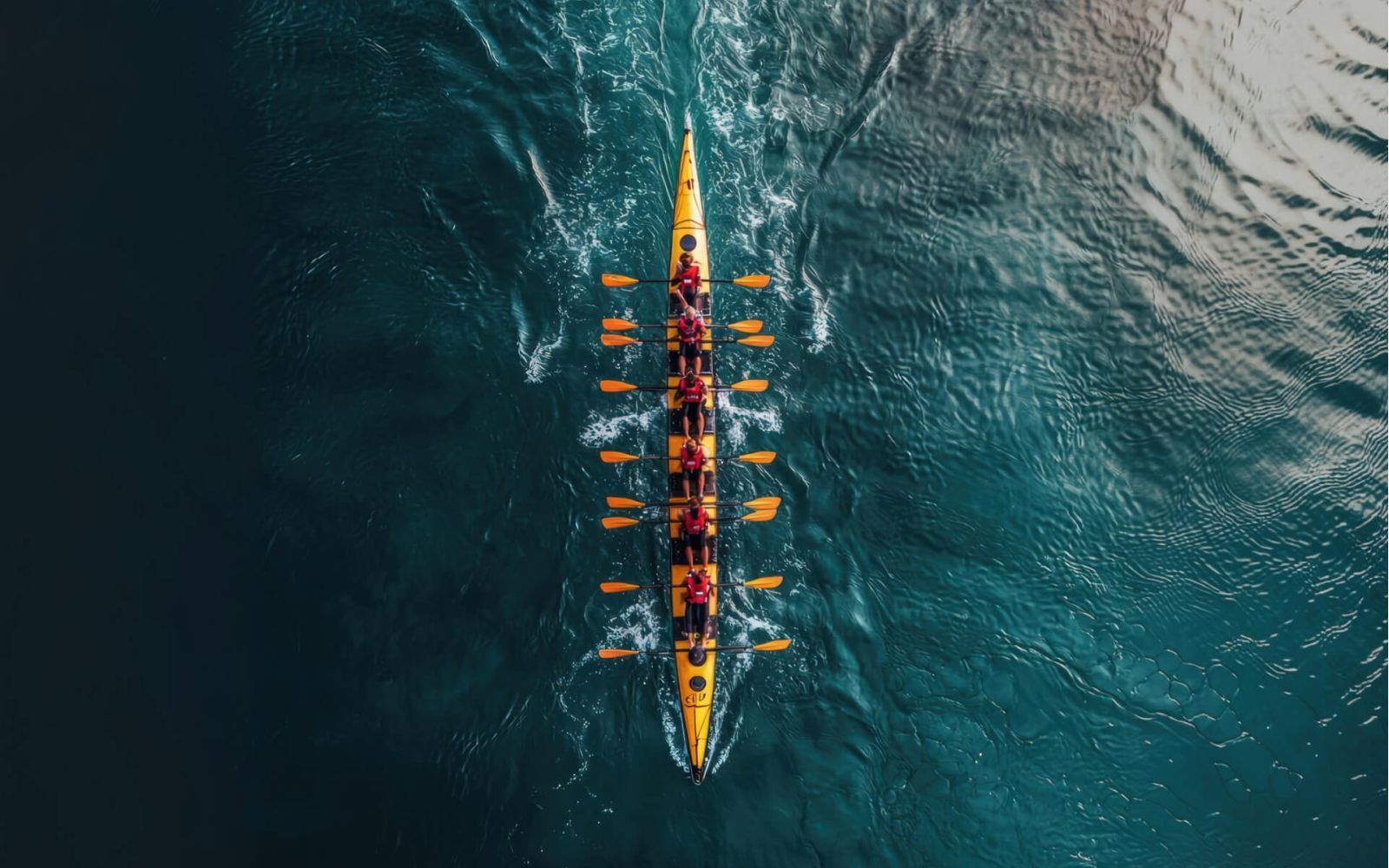 Rowing team racing in narrow boat on water